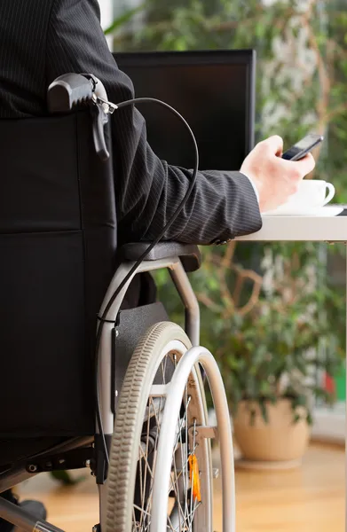 Handicapped uomo d'affari sms durante il lavoro — Foto Stock