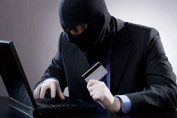 黑客持有一张信用卡 — 图库照片