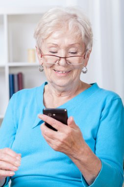 Cep telefonu kullanan yaşlı bir kadın.