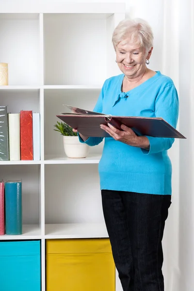 Senior lady viewing family album — Stock Photo, Image