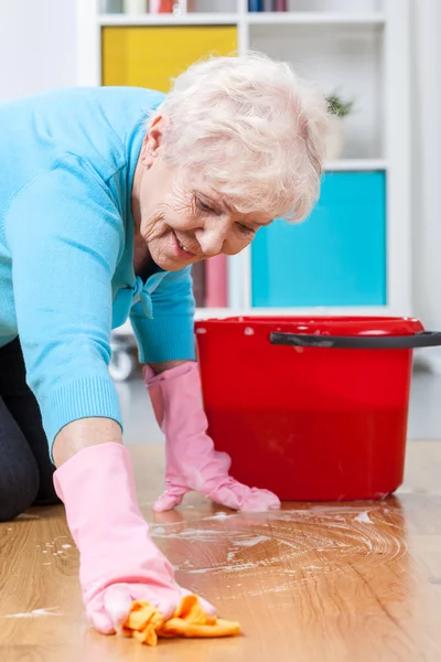Äldre kvinna tvätta golvet — Stockfoto