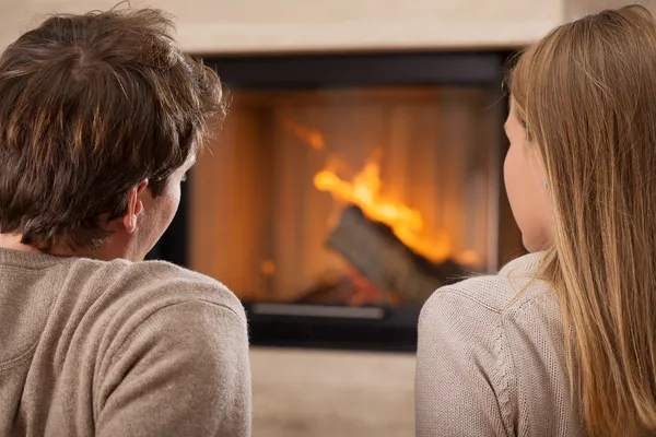 Sitting by fireplace — Stock Photo, Image