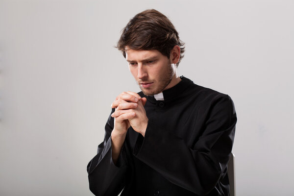 Священник молится.
