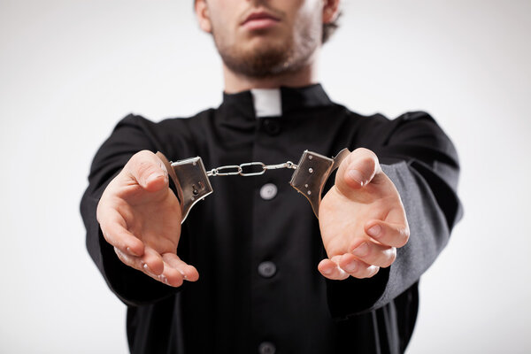 Priest handcuffed