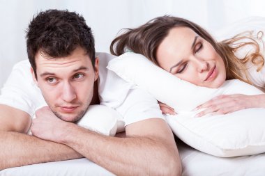 Sleeping wife and thoughtful husband