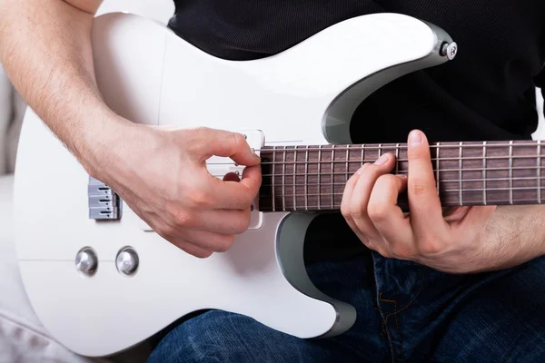 Homme assis jouant de la guitare — Photo