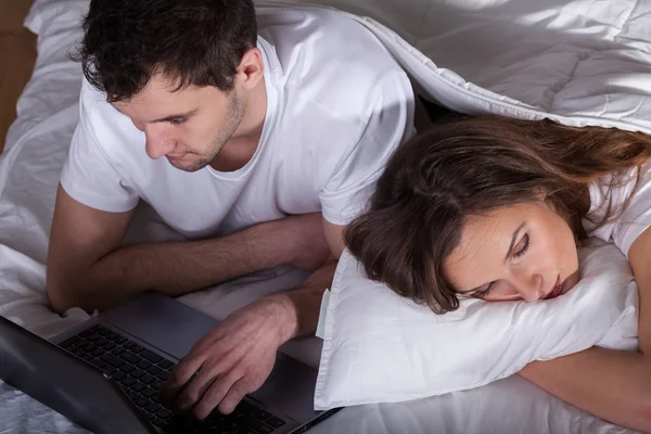 Schlafende ehefrau und ehemann mit computer — Stockfoto