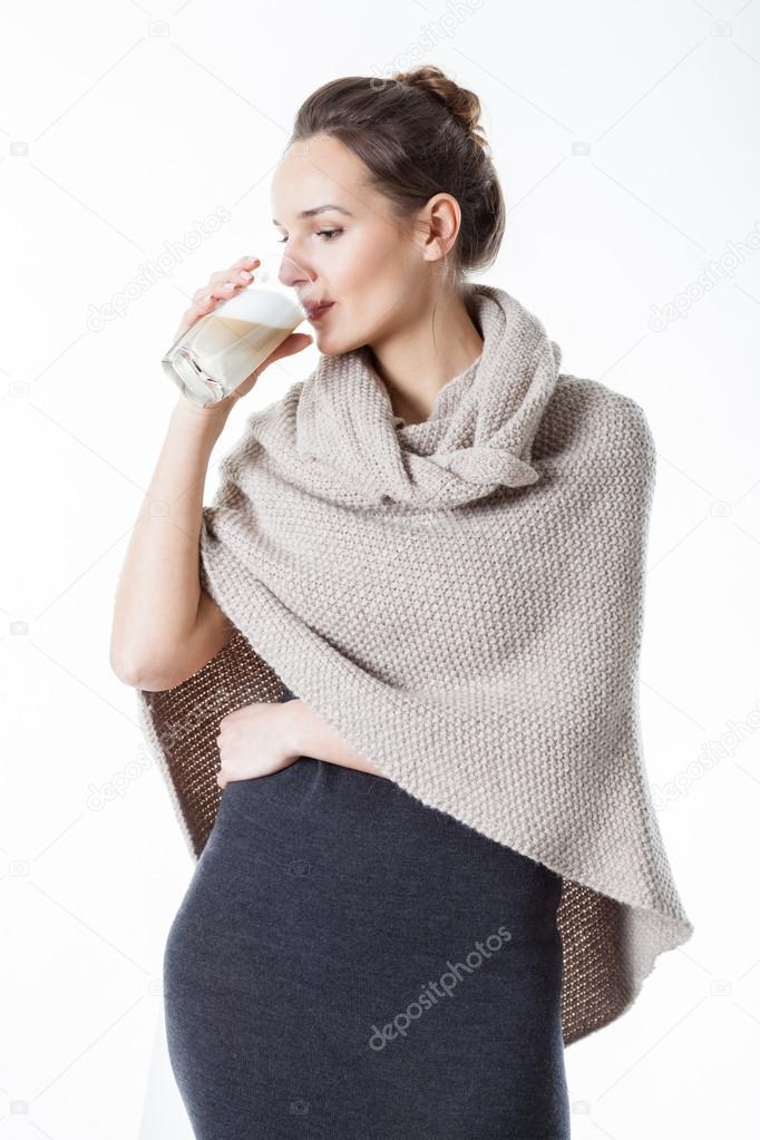 Woman in poncho drinking coffee