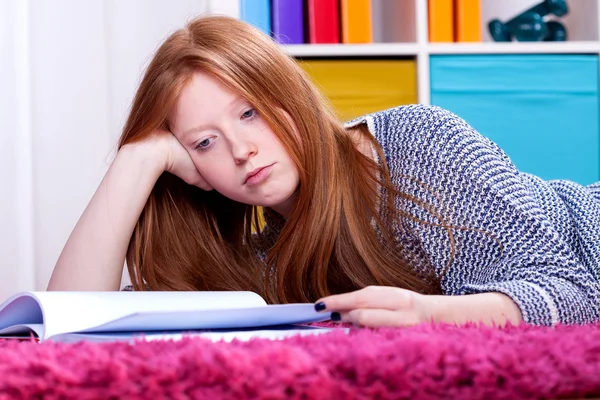 Girl lying and studying Stock Picture