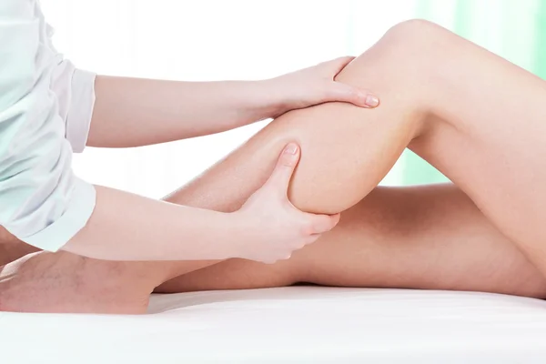 Hands massaging female leg — Stock Photo, Image