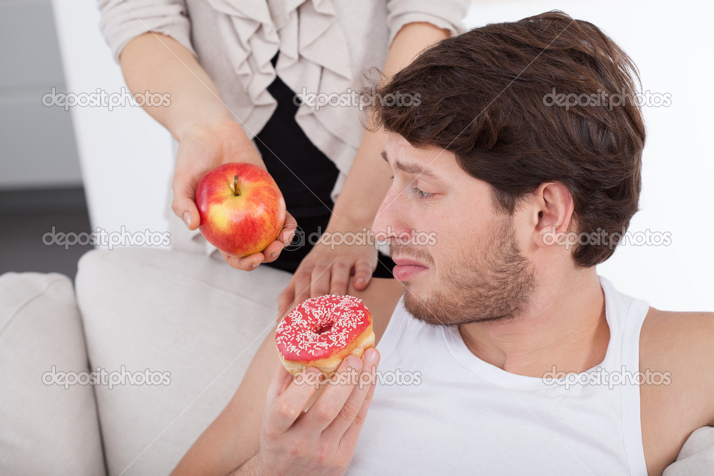 Man choosing donut instead of apple