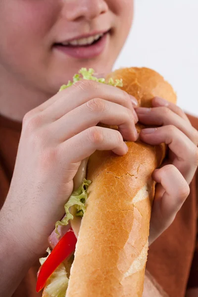 Jeune homme manger sandwich — Photo