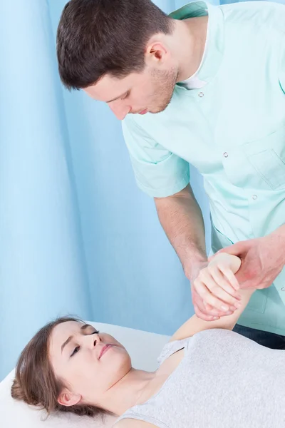 Fisioterapeuta examinando braço — Fotografia de Stock