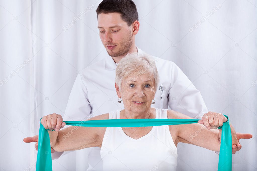 Physiotherapist assisting elderly woman