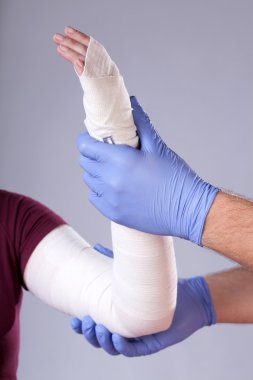 bandajlı kolunu tutan doktor