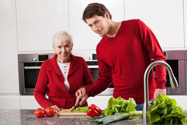 Family making salad together — Stock Photo, Image