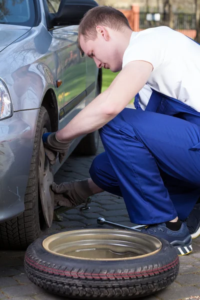 Mechanic changing flat tyre — Stock Photo, Image