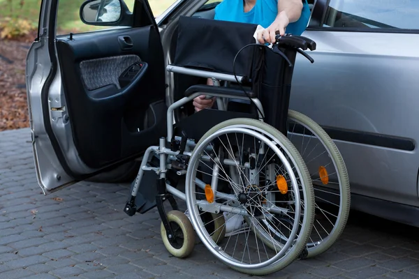 Mann packt Rollstuhl in Auto — Stockfoto