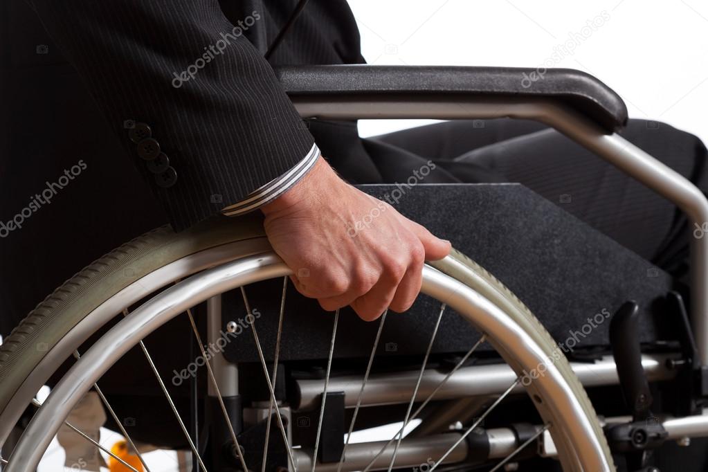 Male hand on wheel of wheelchair