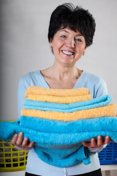 Smiling woman with towels — Stock Photo, Image