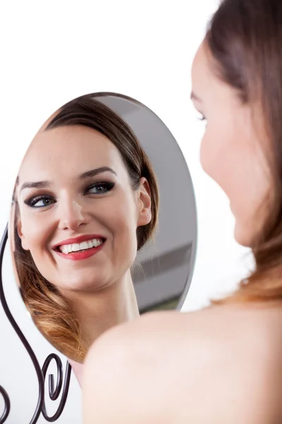 Frau blickt in den Spiegel — Stockfoto