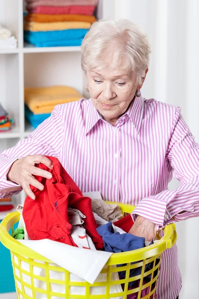 Elderly woman doing laundry — Stock Photo, Image