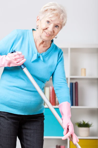 Mujer anciana barriendo piso — Foto de Stock