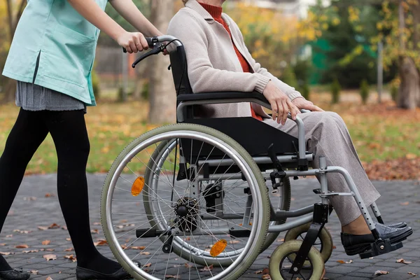 Senhora em cadeira de rodas e enfermeira — Fotografia de Stock