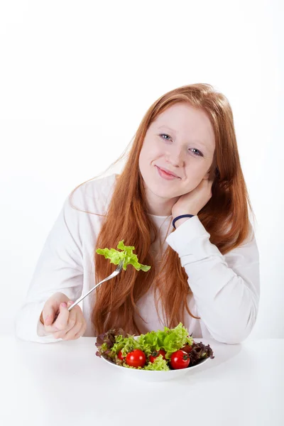 Girl with fork in hand eating vegetable — Stock Photo, Image
