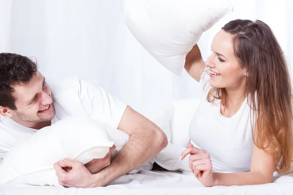 Couple's bed pillow fight — Stock Photo, Image