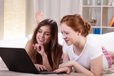 Arkadaş grubu bilgisayar yatakta