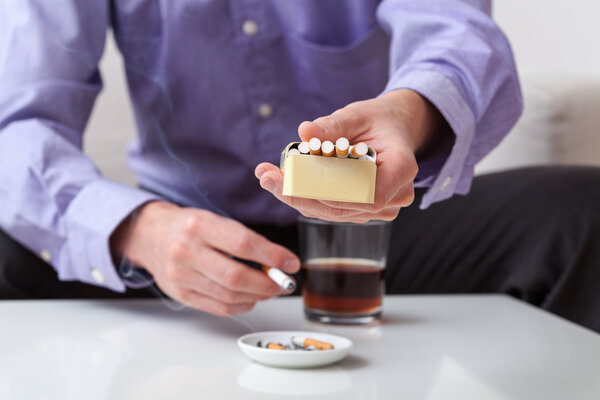 Человек с пачкой сигарет
