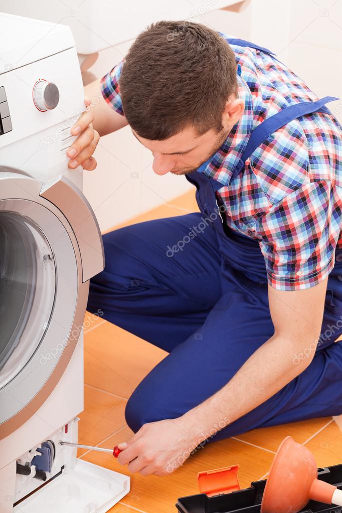 Repairman fixing washing machine