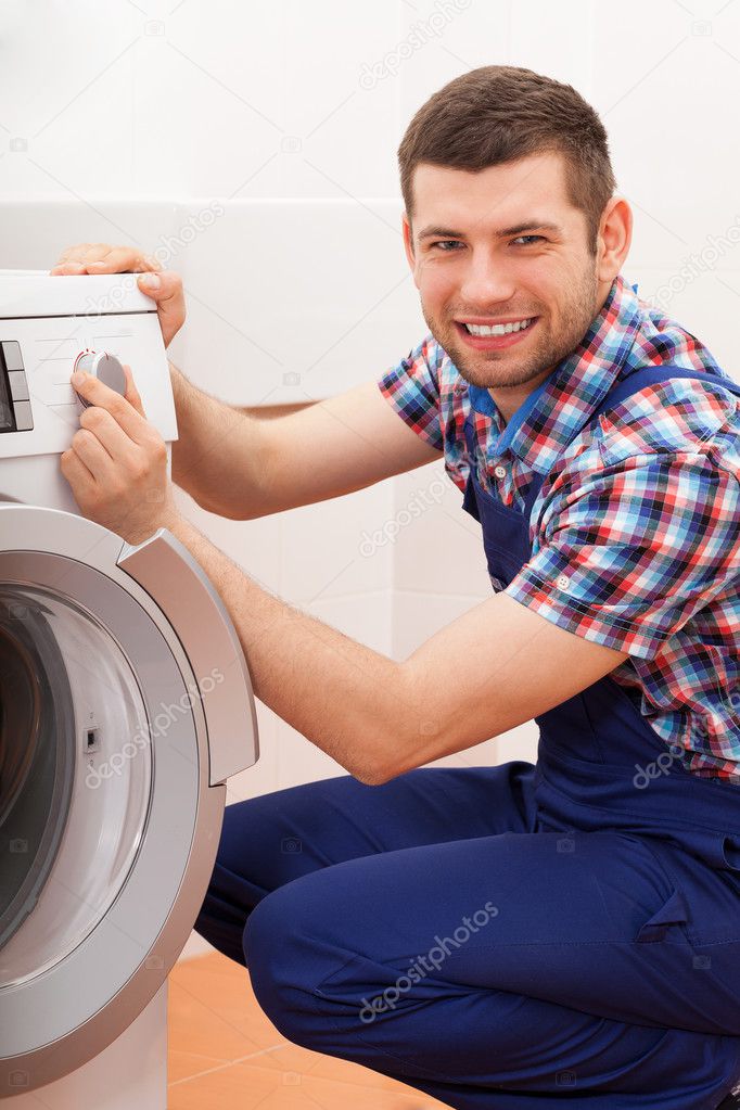 Plumber repairing washing machine