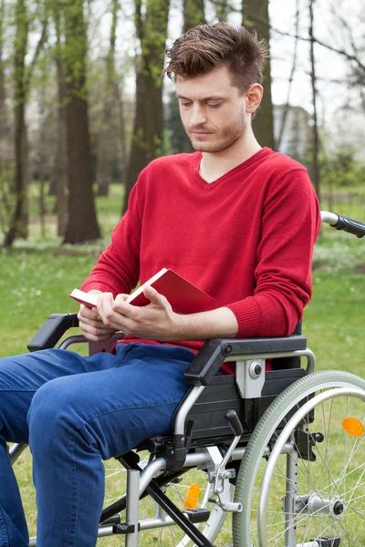 Funktionshindrade läser en bok i trädgården — Stockfoto