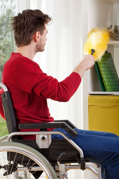 Hombre en silla de ruedas durante la limpieza —  Fotos de Stock