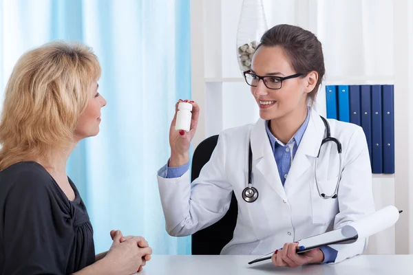 Lächelnder Arzt gibt einem Patienten Pillen — Stockfoto