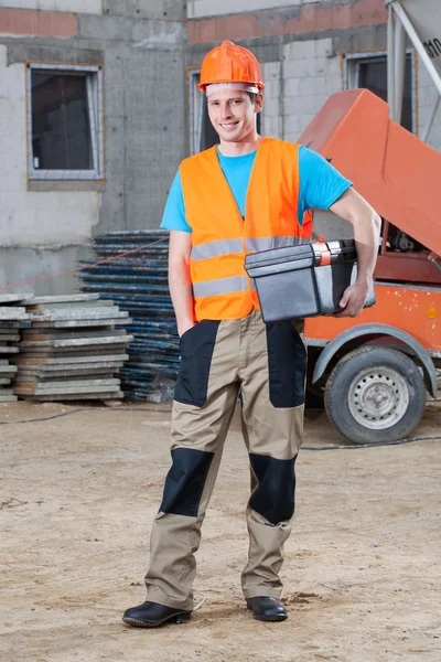 Smiling builder keeping toolbox — Stock Photo, Image