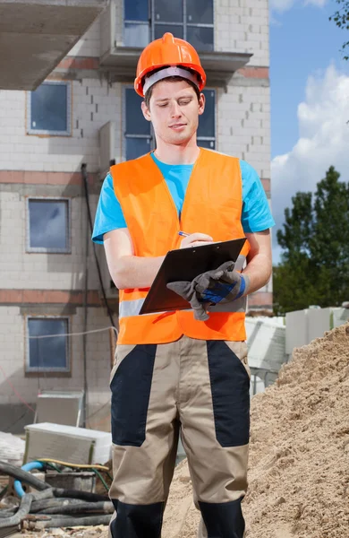 Ingénieur remplissant les papiers sur le chantier — Photo