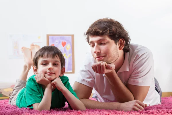 Pai e filho descansando no tapete — Fotografia de Stock