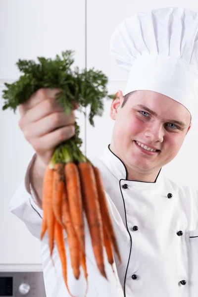 Lachende kok met wortelen — Stockfoto