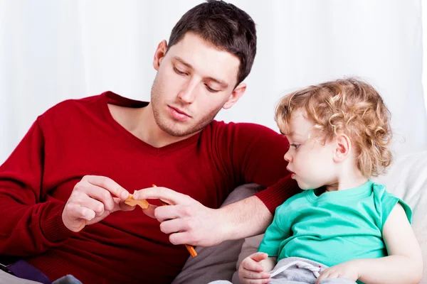 Papa zeigt seinem Sohn ein Spielzeug — Stockfoto