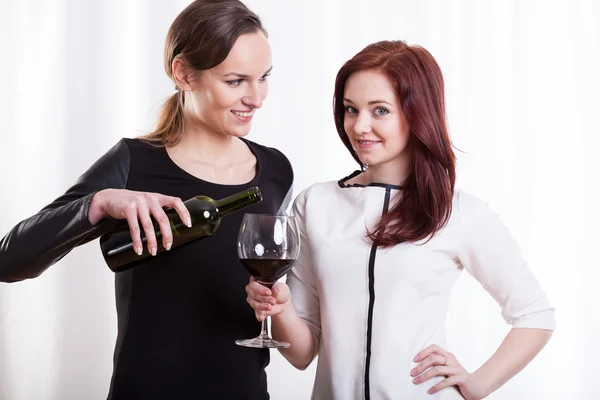 Junge Frau schenkt Wein für ihre Freundin ein — Stockfoto