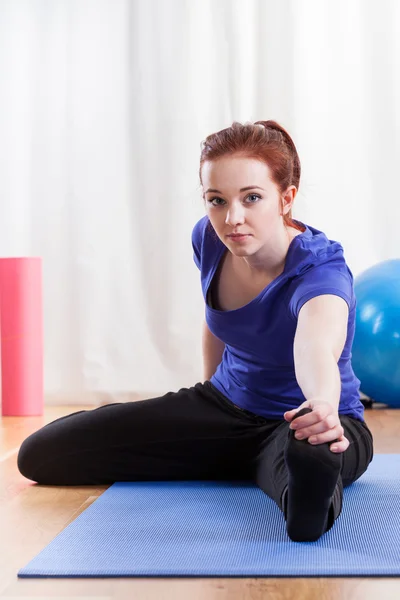 Girl doing the hamstring stretch — Stock Photo, Image