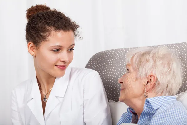 Volwassen dame en verpleegkundige lachend samen — Stockfoto