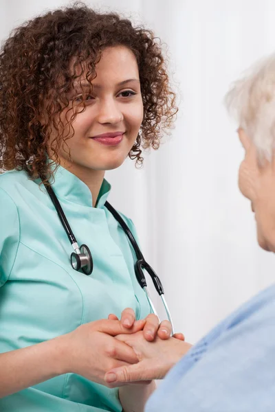 Young nurse holding a woman's hand older — Stock Photo, Image