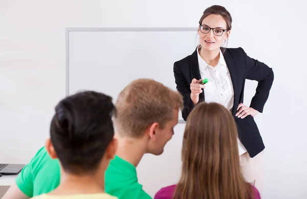 Unga lärare pekar på talande student — Stockfoto