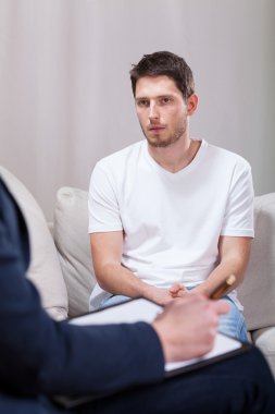 Psikoterapist ile konuşurken üzgün bir adam