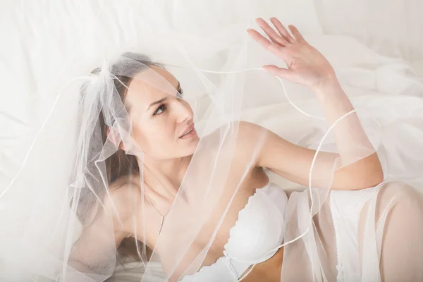 Femme en lingerie nuptiale couvrant son visage avec un voile — Photo