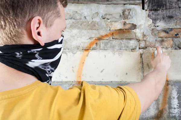 Hooligan painting graffiti — Stock Photo, Image